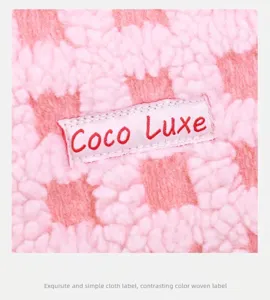 Macro-opname van roze en witte geruite wafelstof met geweven Coco Luxe-label