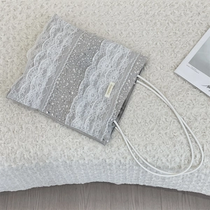 Detail of grey lace tote bag with floral patterns, sequins, and crystal embellishments
