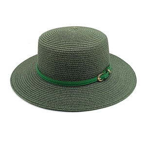 Détail d'un chapeau de paille vert foncé avec ruban vert clair et boucle dorée