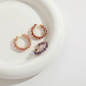 Three-piece gold wire-wrapped ear cuffs with pink, red, and purple natural stone beads