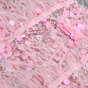 Detail of pink sequins and ostrich feathers on a party dress with sparkling texture
