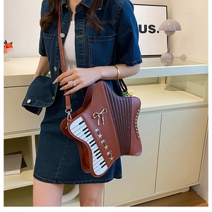 Detail of star-shaped brown crossbody bag with piano key patterns and metal star charms