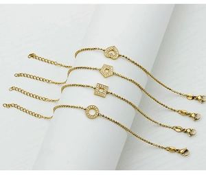 Detailed view of four gold-plated bracelets with heart and geometric zircon charms