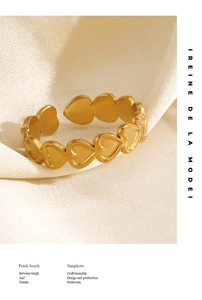Detailed close-up of matte 18K gold-plated heart-shaped adjustable ring on silk fabric