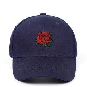 Détail de la broderie rose rouge sur une casquette de baseball en coton bleu marine