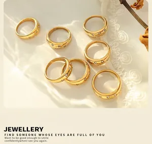 Flat lay of gold star-patterned zircon rings set on white lace and dried flowers