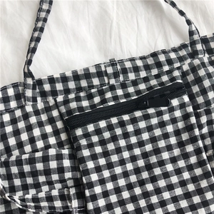 Classic black and white checkered canvas tote bag with front zipper pocket detail