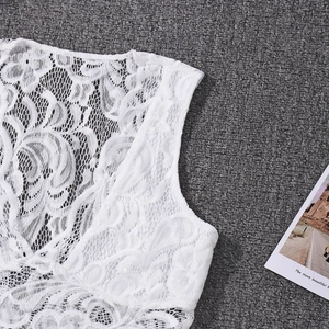 Detailed macro view of white floral lace fabric with intricate cutout patterns