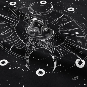 Close-up of bohemian tapestry fabric showing white moon and star patterns on black