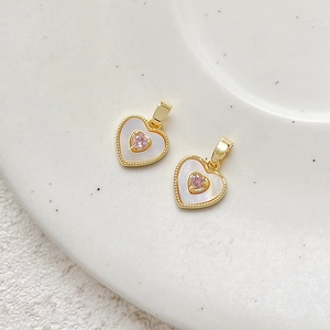 Detail of 18k gold plated heart charm with white mother of pearl and pink zircon stone