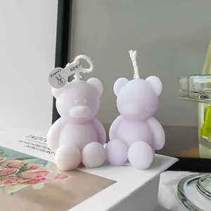Two lavender bear-shaped scented candles handcrafted on white book for home decor