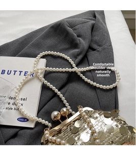 Detailed macro view of large gold sequins and pearl strap on luxury evening bag