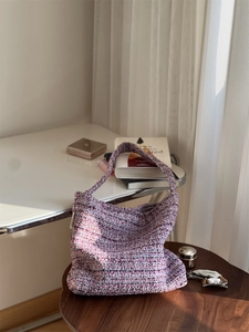 Gros plan sur la texture épaisse du sac en tissu tweed tissé violet et rose élégant