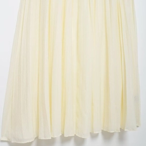 Elegant pale yellow pleated midi skirt with lightweight fabric and flowing drape