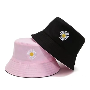 Detail of embroidered white daisy flowers on black and pink cotton bucket hats