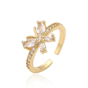Golden butterfly open ring with marquise zircon stones on a white mirror surface