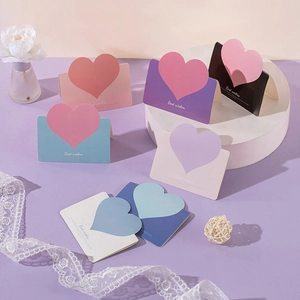 Close-up of heart-shaped folding cards with Best wishes text and lace decorations