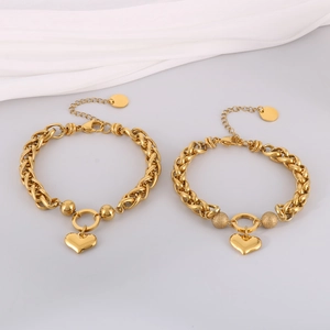 Detailed macro view of heart charm gold-plated bracelets with glossy and frosted beads