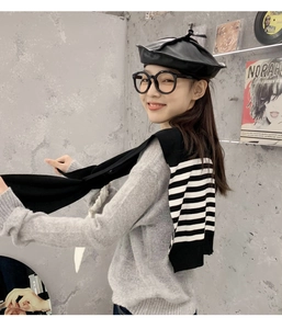 Lifestyle view showing the back style of a striped knitted shawl scarf over a grey sweater