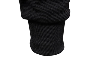 Detail of black men's jacket showing waffle texture fabric and elastic ribbed cuffs