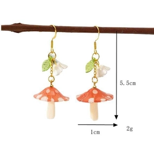 Detail view of red mushroom earrings with white flowers and size markings of 5.5cm height