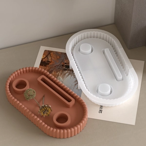 Detail of wavy edge oval silicone mold and terracotta resin tray with three compartments