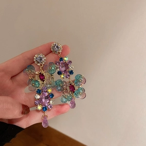 Detailed view of colorful crystal flower earrings with vintage gold metal setting