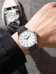 Close-up of minimalist watch with white dial, date display and grey leather strap on wrist
