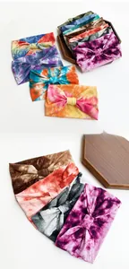 Detailed close-up of colorful tie-dye patterns on elastic yoga headbands with bow knot