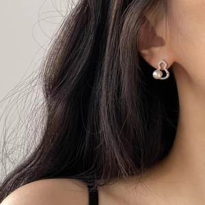 Elegant silver heart-shaped earrings with sparkling zircons and a pearl on model