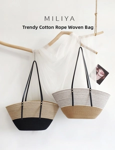 Detail of color-block cotton rope woven tote bags with leather straps on a branch