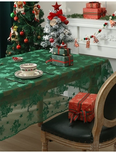 Detailed texture of green lace Christmas tablecloth with Santa and reindeer patterns