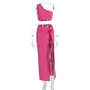 Détail du crop top rouge rose et jupe fendue avec applique de fleur décorative