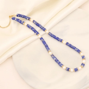 Fashion natural stone and pearl necklace with golden beads on white silk background