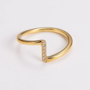 Macro detail of 18K gold wave ring featuring vertical bar and pavé crystal setting