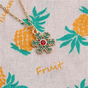 Christmas necklace with green snowflake pendant and red gemstone on golden chain