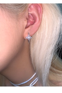 Side view of a silver star-shaped earring with zircon on ear showing the fit