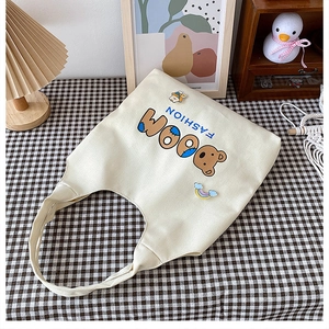Detailansicht der cremefarbenen Canvas-Tasche mit Bären-Print und Fashion Boom Schriftzug