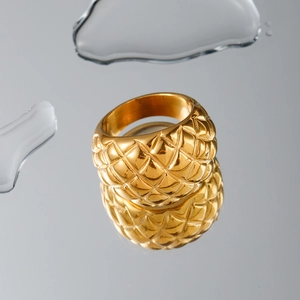Anello in acciaio inossidabile dorato con motivo a rombi su piano riflettente