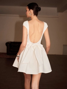 Robe mini blanche dos nu élégante avec un grand nœud et une silhouette évasée