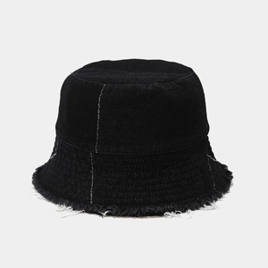 Detail of black denim bucket hat with frayed edges and white contrast stitching