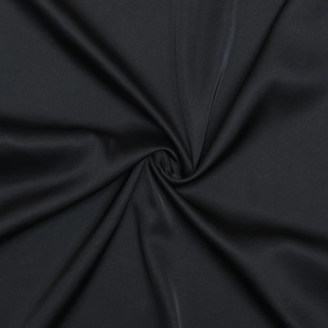Detail of soft black sheer mesh fabric with elegant swirling drapes and subtle texture