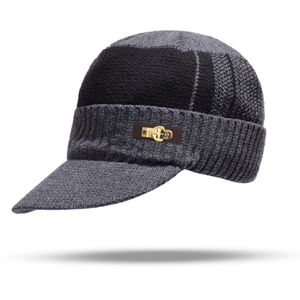 Close-up of knit winter visor hat with a 1989 golden metal logo on a brown leather patch