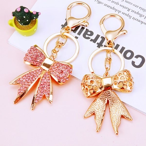 Detailed macro view of pink crystal bow and hollow gold keychain with lobster clasp