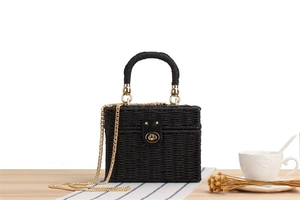 Detail of black woven box bag with vintage gold clasp and elegant metal chain strap