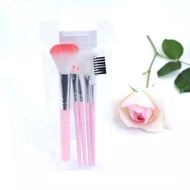 Detailed view of pink mermaid makeup brushes with soft bristles and flower decoration