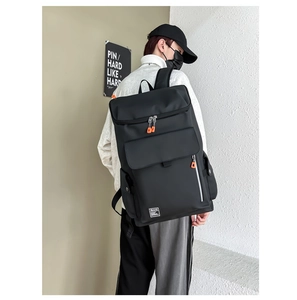 Detail of black nylon travel backpack showing side zipper and white Bpunk woven label