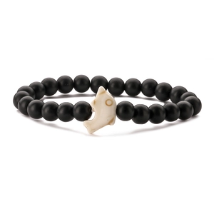 Detail of beaded bracelet with matte black round beads and white dolphin charm feature