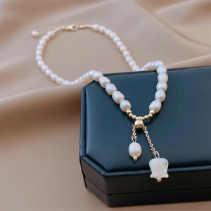 Detail of freshwater pearl necklace with floral pendant displayed on a premium jewelry box
