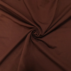 Macro shot of dark brown elastic fabric with pleated texture for slim fit dress